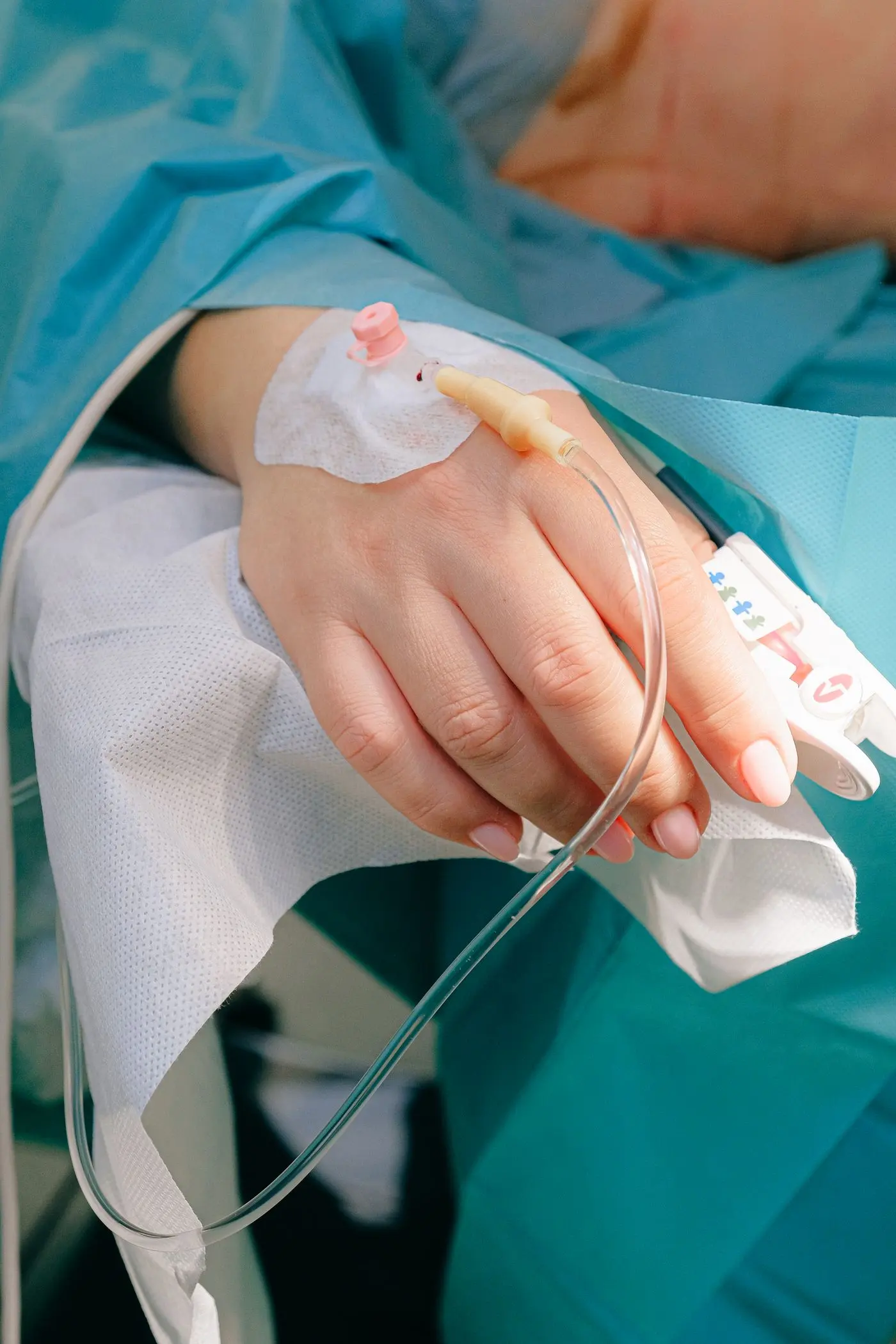 Mano de una paciente con una vía intravenosa instalada durante una sesión de tratamiento